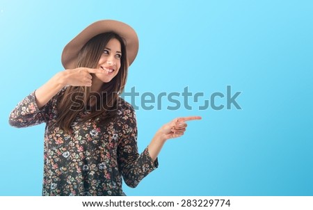 Woman pointing lateral over colorful background