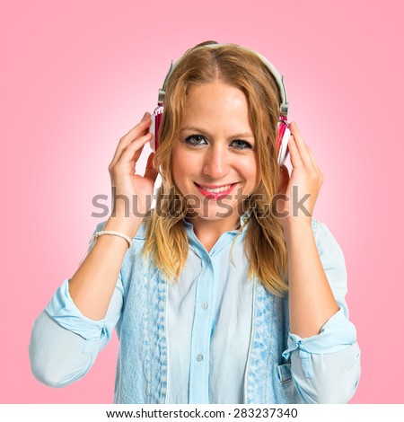 Young woman listening music over colorful background