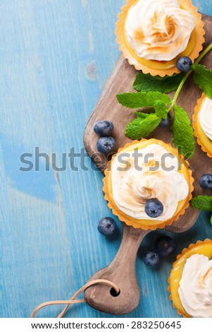 Mini lime curd tartlets with meringue. Holiday concept. Top view. Background with copy space.
