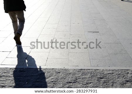 walking man, from backside. Shadow Royalty-Free Stock Photo #283297931