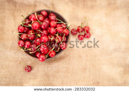 ripe cherries in a bowl and next to her