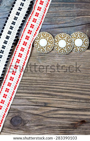 vintage buttons and antique band with embroidered ornaments on a textured surface aged boards