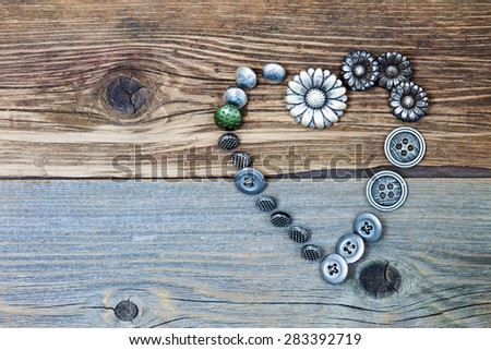 Heart from vintage classical buttons on the old textured boards