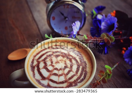 coffee latte art and watch on wooden table ,photo in vintage color 
