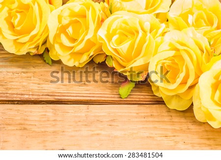 Yellow roses flowers on a brown, vintage wooden planks background, wedding invitation, greeting card, mothers day and invitation card
