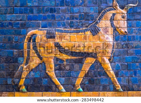 Ancient mosaic on the Ishtar Gate wall with mythical bull, Istanbul museum. Babylonian mosaic, fragment of the Ishtar Gate. Royalty-Free Stock Photo #283498442