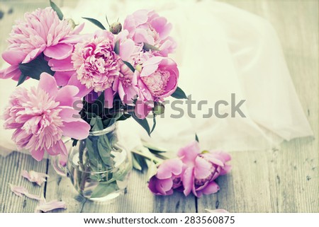 Pink roses(peony) in vase on wooden floor - retro styled photo
