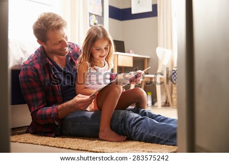 Father and young daughter reading together Royalty-Free Stock Photo #283575242