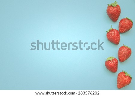 Some strawberries in line with a lot of copy space for your text or editing. 
