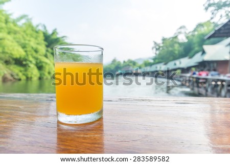 Orange juice glass on the table of the natural background