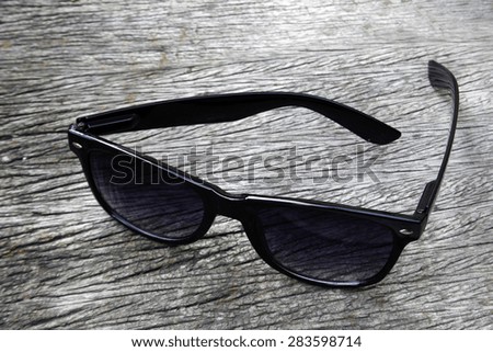 black eye glasses on wood background