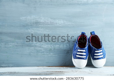 Colorful toddler shoes on wooden background Royalty-Free Stock Photo #283630775