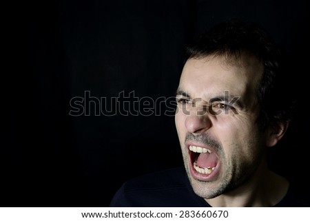 shouting young man, black background Royalty-Free Stock Photo #283660670