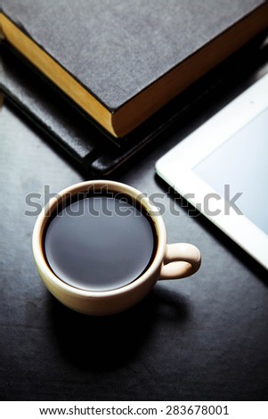 empty tablet pc and a coffee and notebook with pen on the office desk