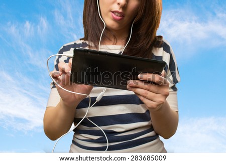 Woman using a tablet. Over clouds background
