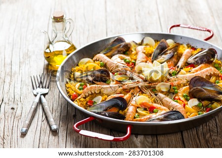 Vegetable paella with seafood on a wooden background Royalty-Free Stock Photo #283701308