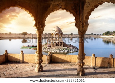 Arches and temple in Gadi Sagar lake at sunset sky in Jaisalmer, Rajasthan, India Royalty-Free Stock Photo #283721051
