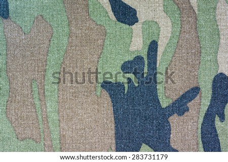close up of worn out dark blue, green and brown color camouflage fabric