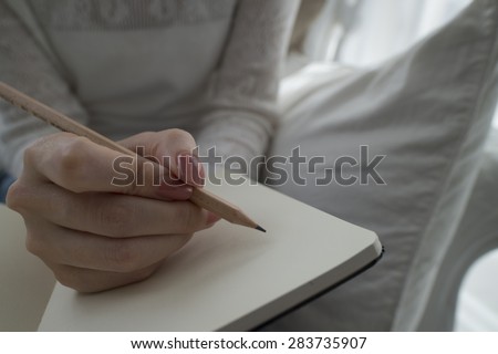 Hand writes a pen in a notebook