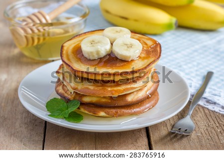 Stack of pancakes with banana and honey Royalty-Free Stock Photo #283765916