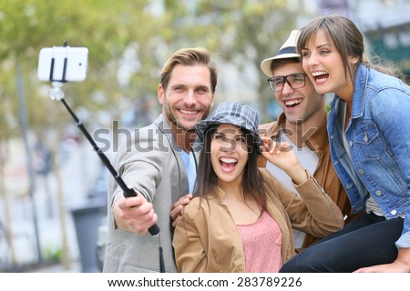 Group of friends taking picture of themselves with smartphone Royalty-Free Stock Photo #283789226