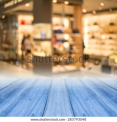Perspective blue wood over blur store of shopping mall blur background with bokeh.