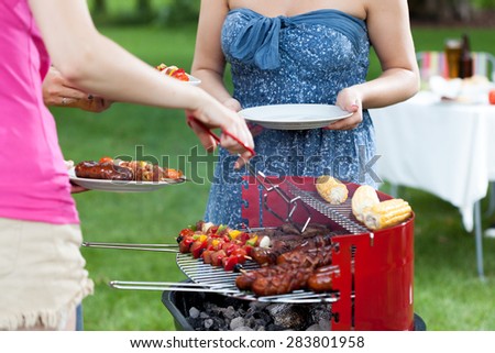 Host serving grilled meals on barbecue party