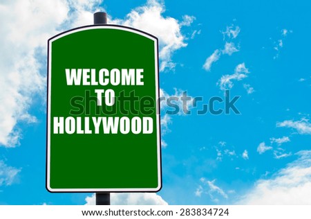 Green road sign with greeting message Welcome to HOLLYWOOD isolated over clear blue sky background with available copy space. Travel destination concept  image