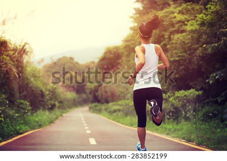 young fitness woman runner running on trail Royalty-Free Stock Photo #283852199