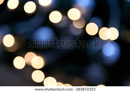 holidays, illumination and electricity concept - colorful bright lights on dark blue night background