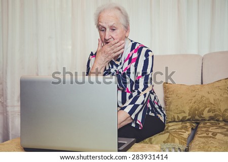 Senior woman shocked with something on laptop screen