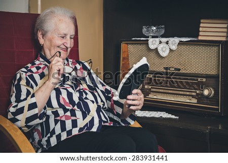 Senior woman smiling and looking at old photo frame
