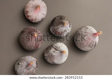 Half a dozen fresh figs on a neutral background
