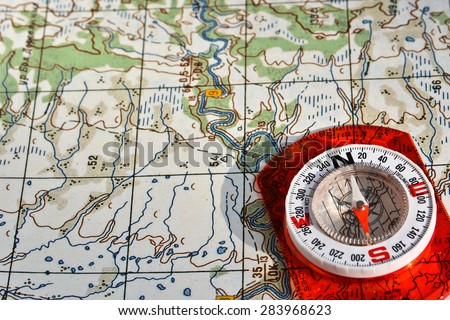 Navigation equipment for orienteering. Magnetic compass and topographic map. Royalty-Free Stock Photo #283968623