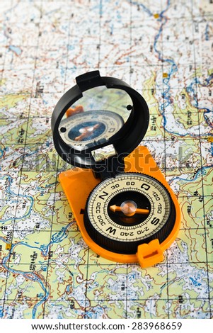 Navigation equipment for orienteering. Magnetic compass and topographic map.