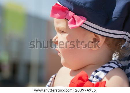 portrait of Cute baby girl in sailor hat, close up, profile