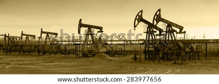 Pump jack group and wellheads. Extraction of oil. Toned.