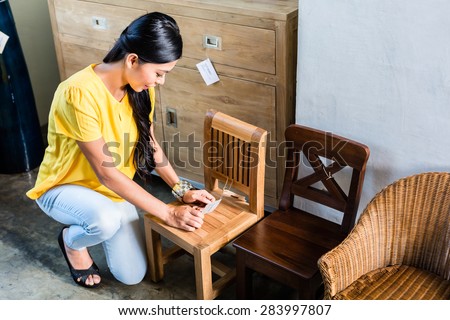 Asian woman in furniture store buying chair