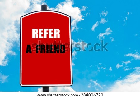 Refer a Friend motivational quote written on red road sign isolated over clear blue sky background. Concept  image with available copy space