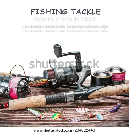 fishing tackle on a wooden table isolated on a white background. Focus on spinning.