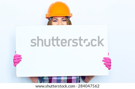 Woman worker builder hiding face behind white sign board. Building helmet. Pink glow.