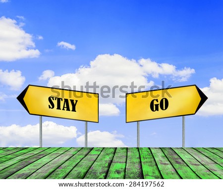Two street signs GO and STAY with beautiful blue sky with cloud closeup and green wooden floor