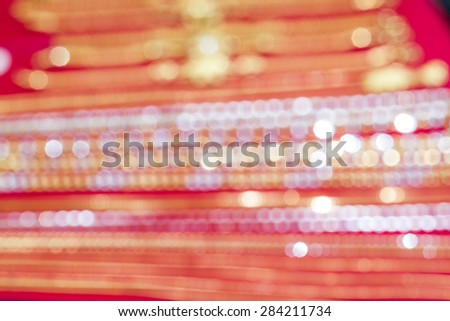 gold and silver bokeh from out of focus jewelry on red background