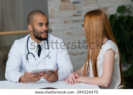 Doctor at work in a hospital. Portrait of confident and professional doctor therapist wearing white medical clothes with his patient. Medical hospital concept.