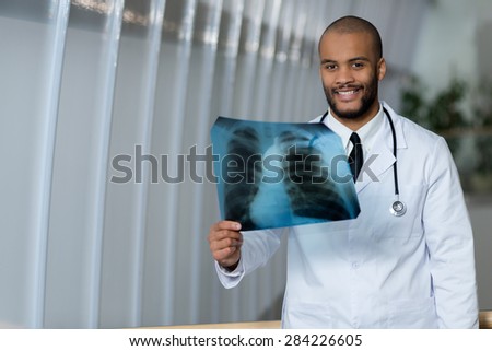 Medical confidence and professionalism. Portrait of confident and experienced doctor therapist wearing white medical clothes and examining x-ray. Healthy lungs and danger of smoking