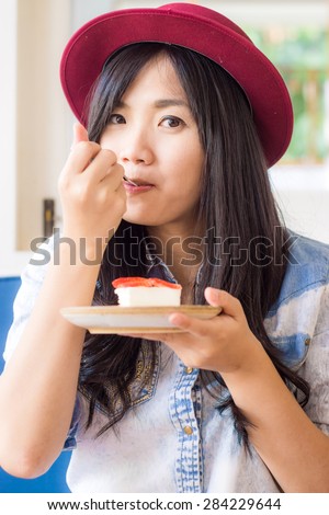 Smiling young asian woman eating cake in bakery shop, Smiling and look so cute