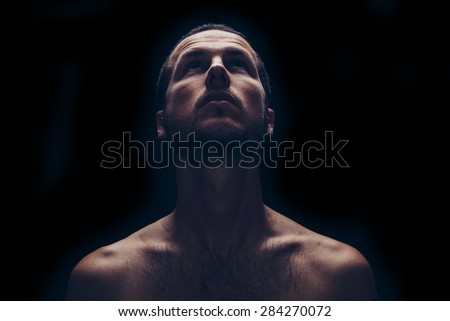 dark portrait of an handsome man looking up Royalty-Free Stock Photo #284270072