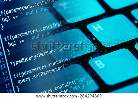 Program code on a monitor and computer keyboard. Small depth of 