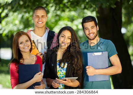 Happy smiling Students with tablet, computer at Park Royalty-Free Stock Photo #284306864