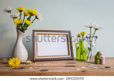 Vintage photo frame and flowers on wooden table over grunge background, Still life style 